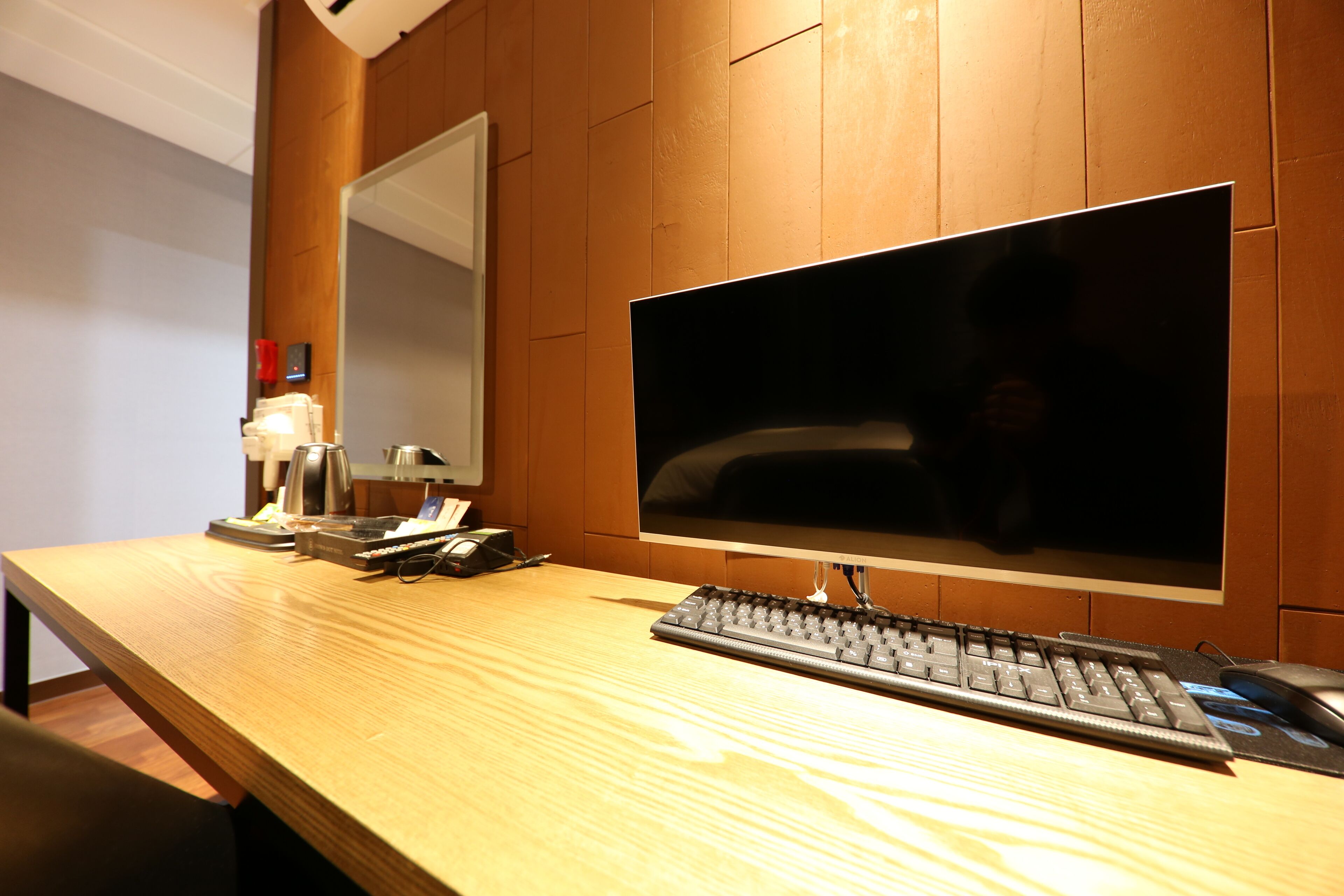 Un escritorio de madera con un monitor de pantalla plana, teclado y ratón.