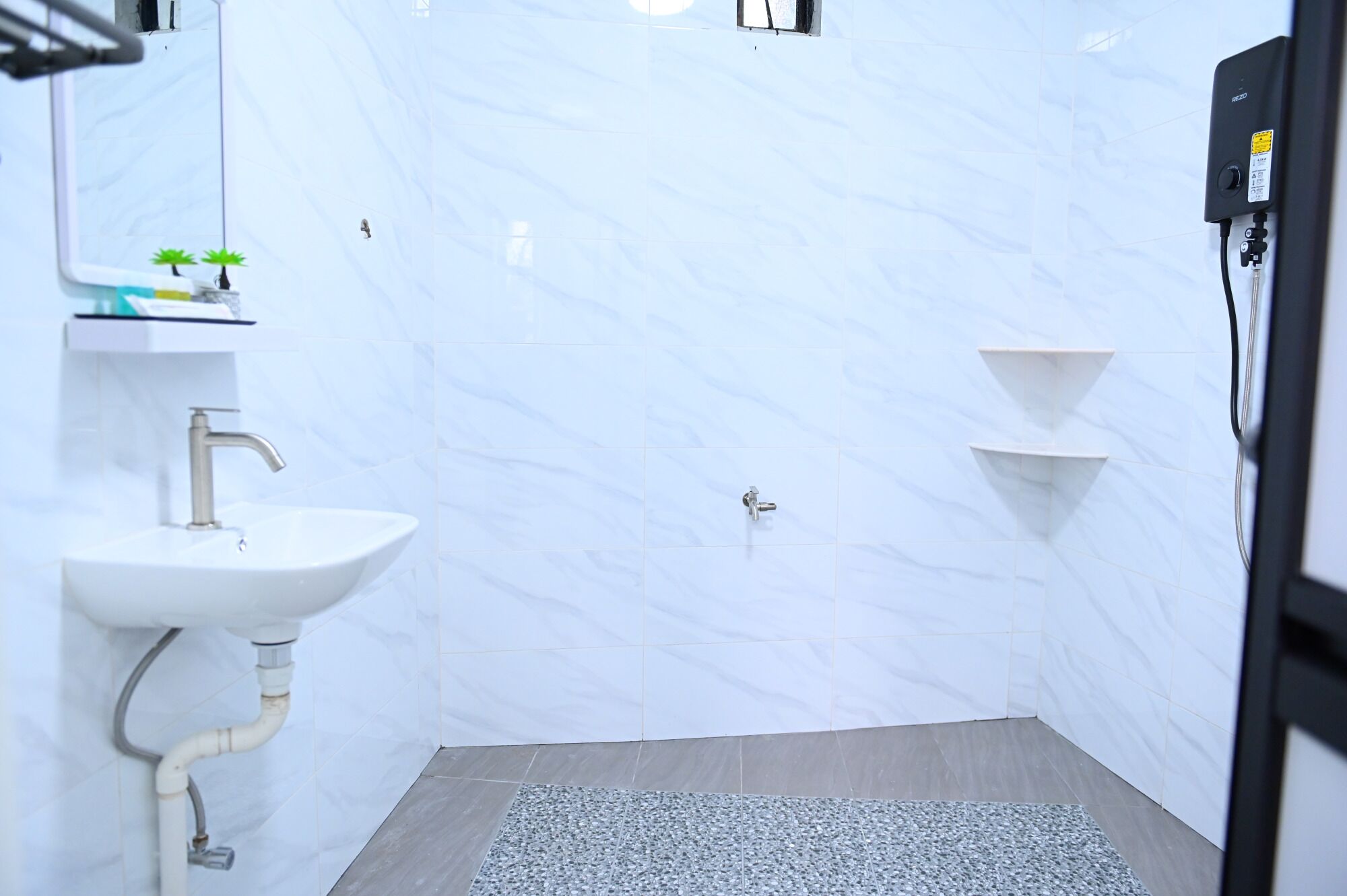 A bathroom with a white sink, mirror, and two towel racks.