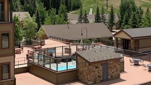 Ein Resort mit Poolbereich, Sitzgelegenheiten im Freien und Blick auf einen bewaldeten Berg.