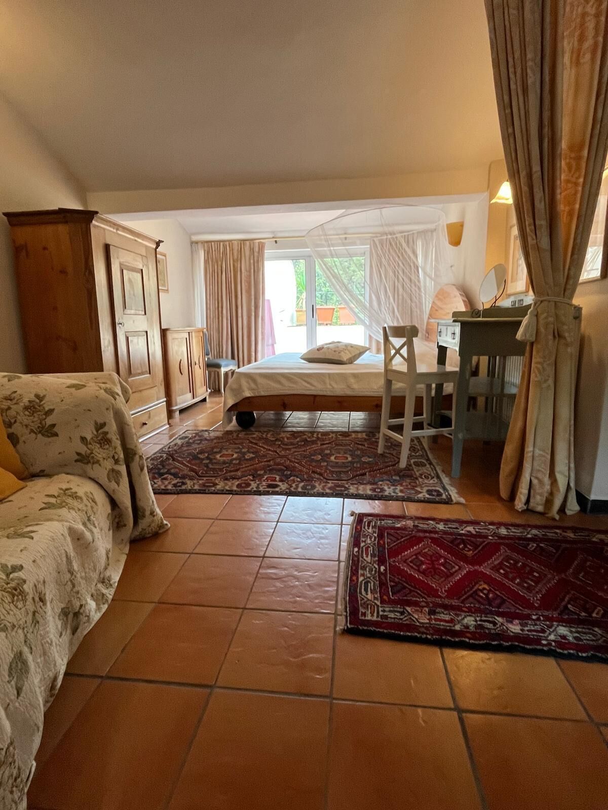 Ein Schlafzimmer mit einem Bett, einem Schreibtisch, einem Stuhl und einem Kleiderschrank.
