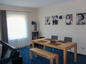 A room with a wooden table, chairs, a bench, a fireplace, and wall art.