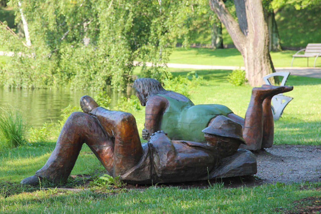Een beeldhouwwerk van twee figuren in een park.