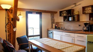Una cocina compacta con zona de comedor, horno integrado y cafetera.