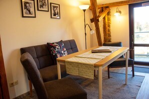 A cozy room with a sofa, a table with a notebook, and a lamp. - Tenne 1 - Müritz apartment (Röbel/Müritz)