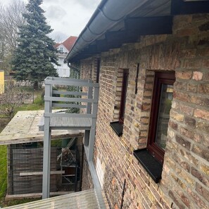 A brick house with a metal staircase leading to a balcony. - Tenne 2 - Müritz apartment (Röbel/Müritz)