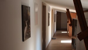 A hallway with wooden flooring, white walls, and artwork. - Tenne 2 - Müritz apartment (Röbel/Müritz)