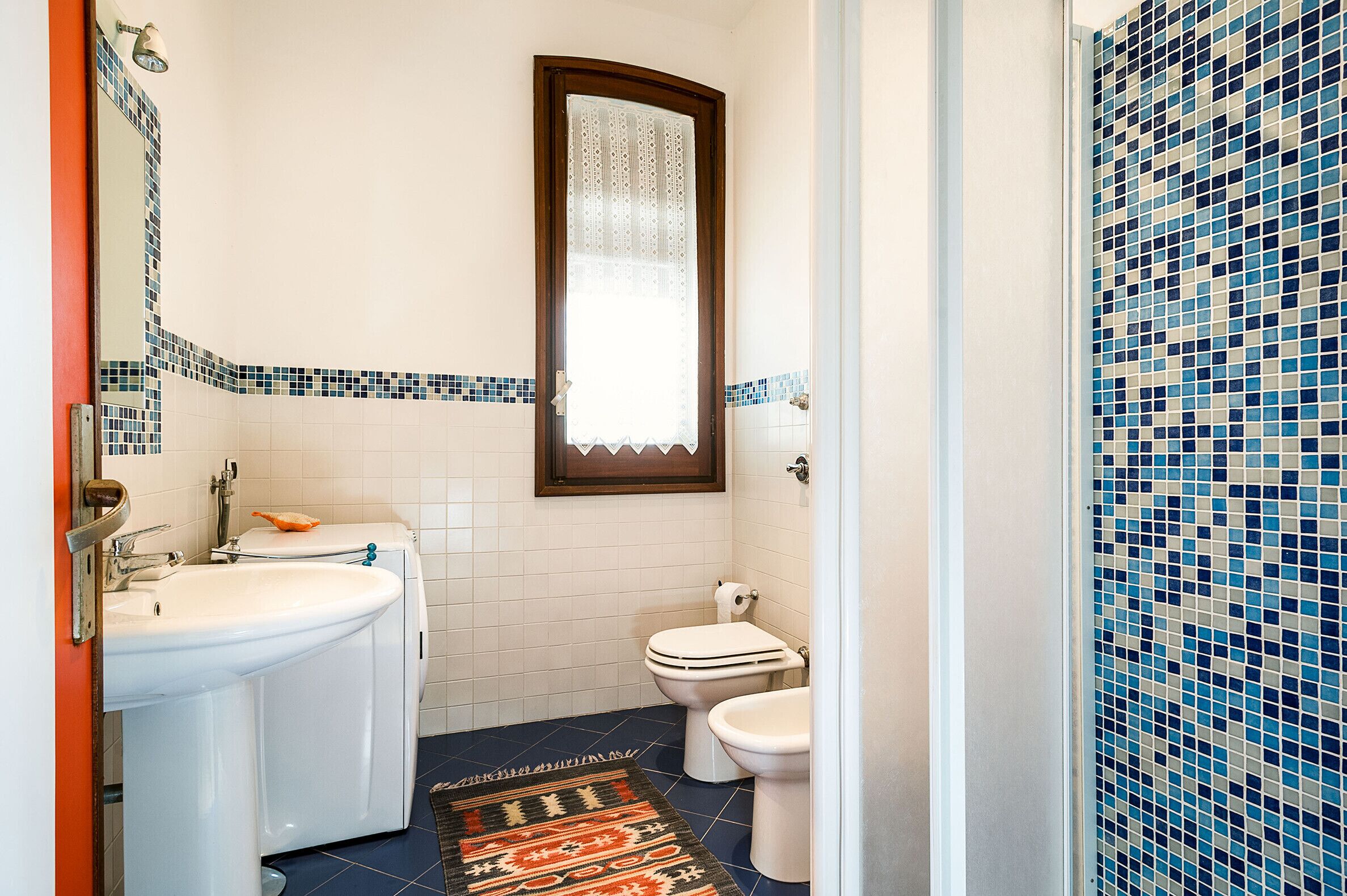 A bathroom with a sink, toilet, and a mirror.
