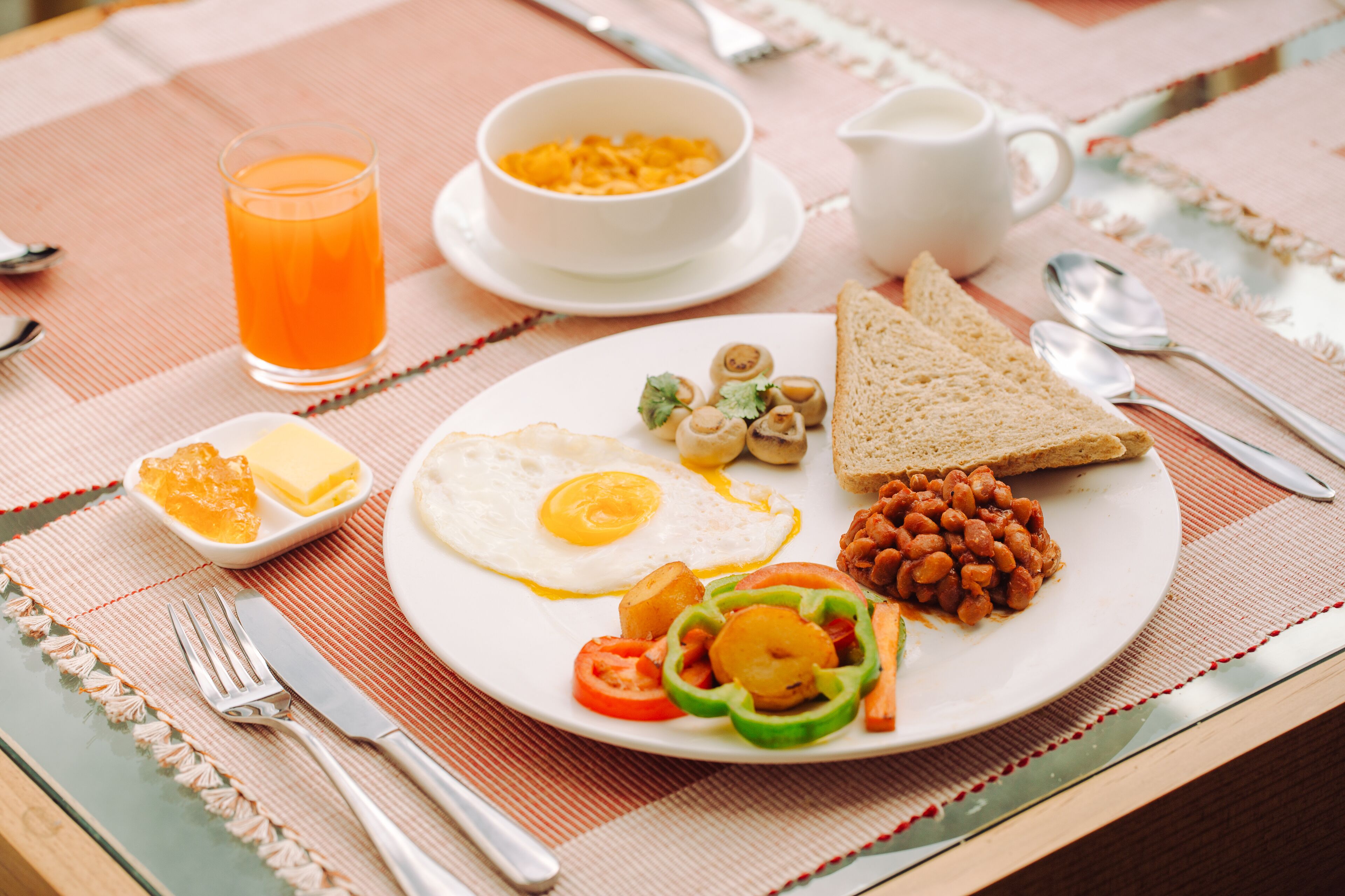 Un plato de desayuno con huevos, frijoles, tostadas y verduras.