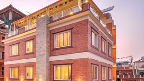 Ein mehrstöckiges Hotel mit Restaurant und Bar im Erdgeschoss, großen Fenstern und einer Ziegel-Fassade.