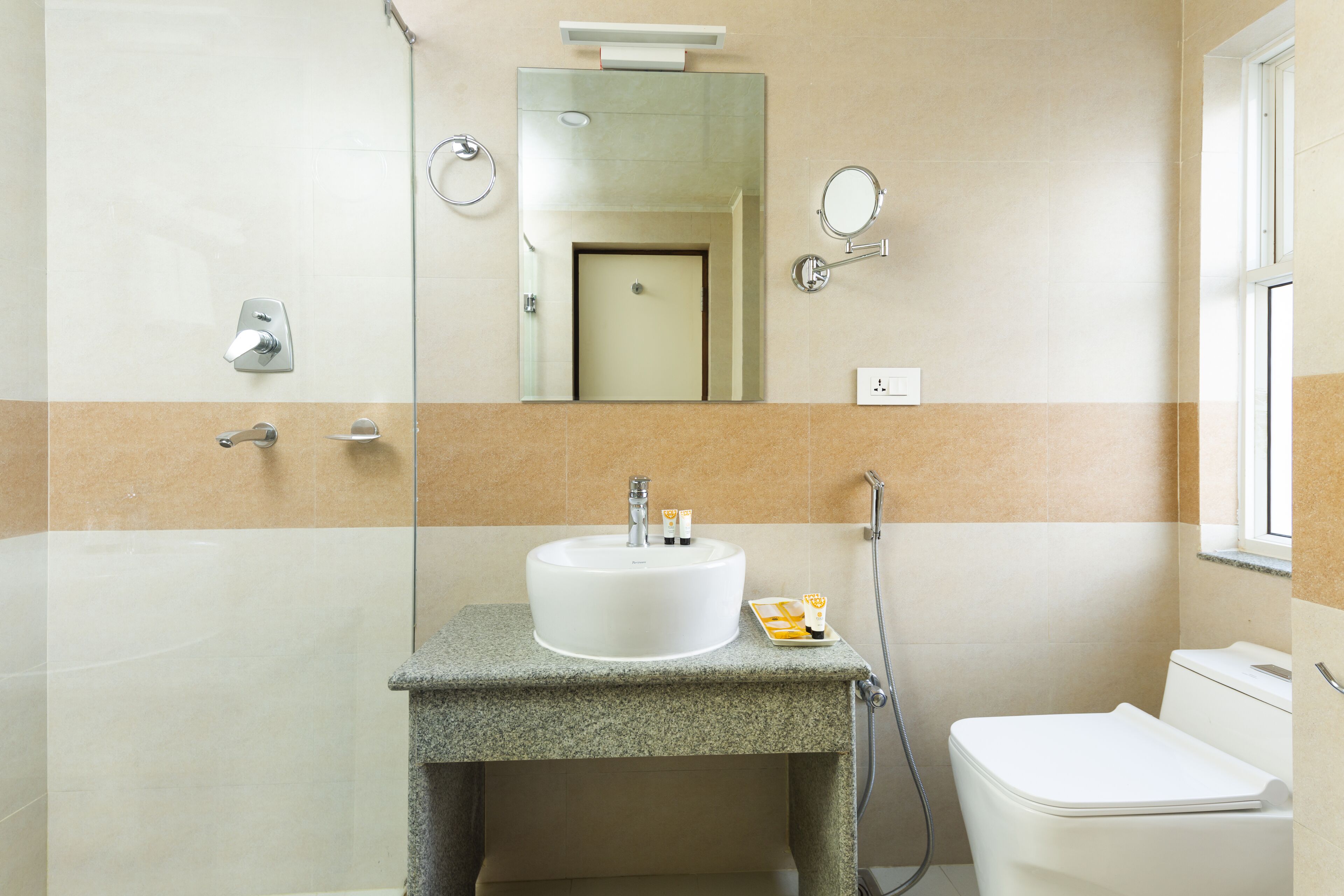 Un baño con un lavamanos blanco, un espejo, un inodoro y una ducha.