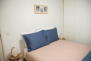A bedroom with a bed, a bedside table, a lamp, and a framed picture on the wall. - Charming apartment with balcony in the heart of Porto (Porto)