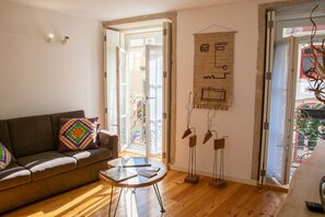 Sala de estar com sofá marrom, mesa de centro redonda e uma obra de arte abstrata na parede.