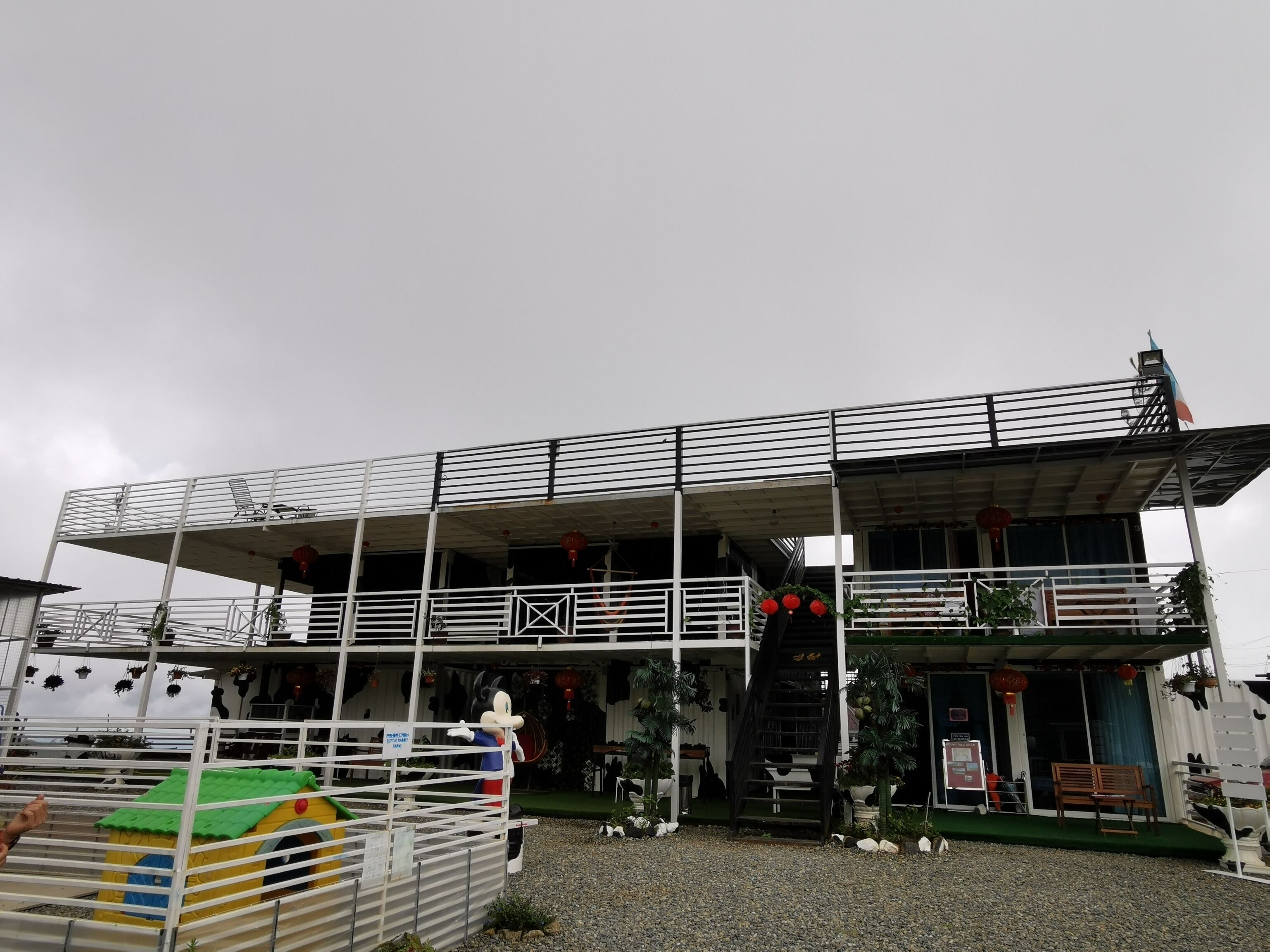 A multi-level building with a covered entrance, outdoor seating, and a mascot figure.