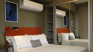 A bedroom with a bed, bedside tables, a mirror, and an air conditioning unit. - #1 Sophisticated Studio on Boaventura Da Silva (Fátima)