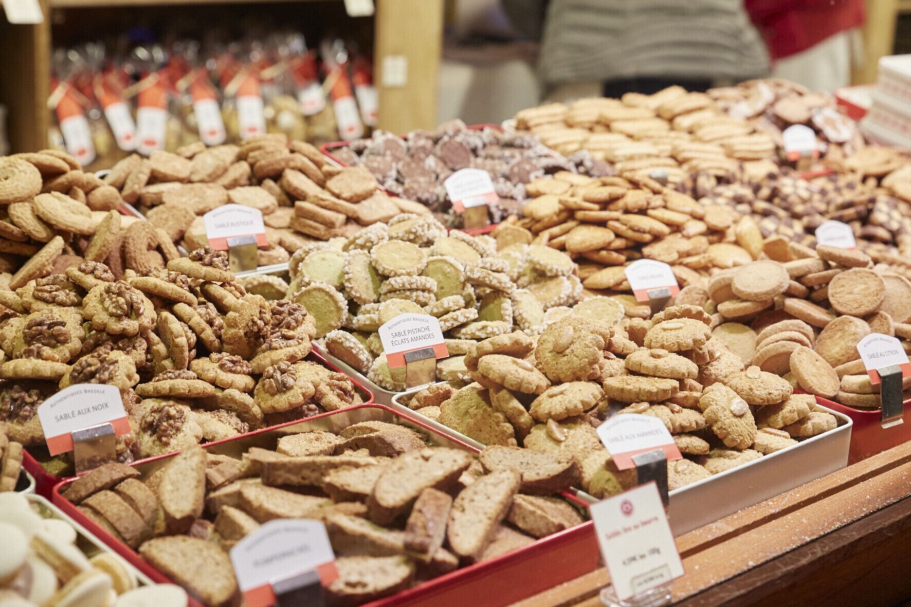 A display of various types of cookies and pastries in a bakery setting.