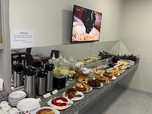 Ein Buffet mit verschiedenen Speisen und einem Schild auf Portugiesisch.