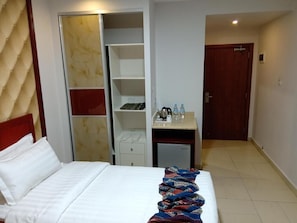 A hotel room with a bed, a wardrobe, a desk with a chair, and a door. - Seven Days Hotel (Aqaba)