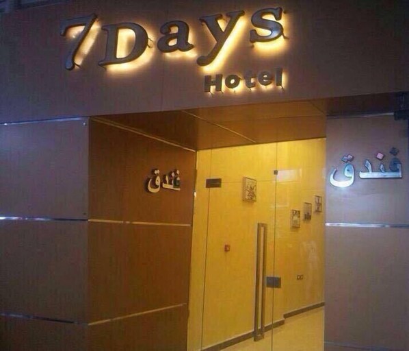 Das Hotel ‚7 Days Hotel‘ mit moderner Gestaltung und beleuchteter Beschilderung, Außenansicht.