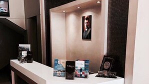 A hotel reception desk with a digital screen, a framed photo, and informational brochures. - Seven Days Hotel (Aqaba)
