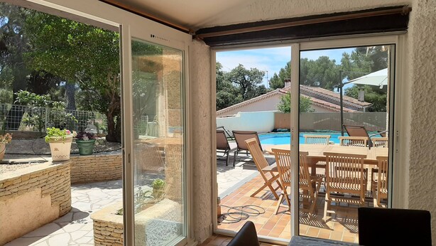 A sunlit patio with a pool, outdoor furniture, and potted plants. - Villa large pool, beach, Sanary harbor on foot (Six-Fours-les-Plages)