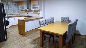 Una cocina moderna con una mesa de comedor de madera y sillas tapizadas de gris.