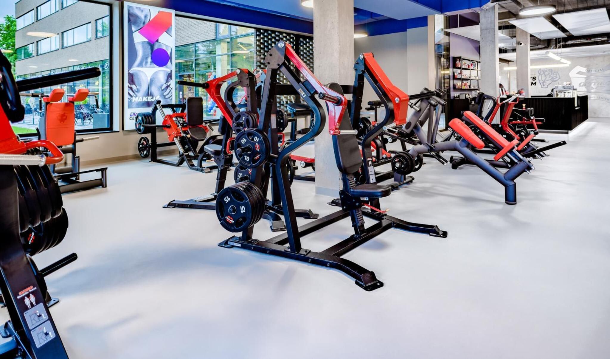 A modern gym with various exercise equipment, including weight machines and benches.