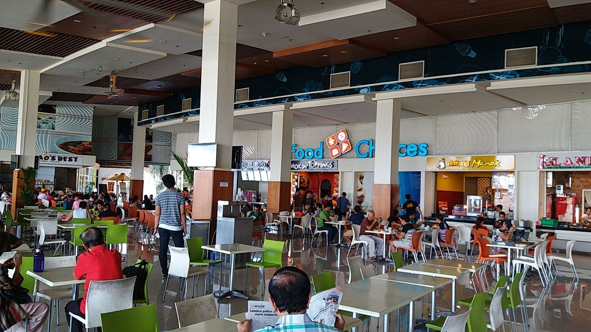 A spacious indoor dining area with multiple seating arrangements and a variety of food outlets.
