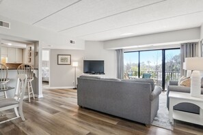Relax in this stylish living room with a sofa, flat-screen TV, and dining area.
