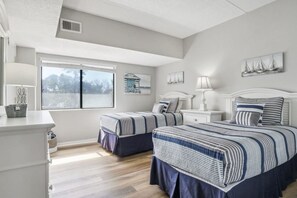 Una camera da letto con due letti, una finestra e vista sull'esterno.