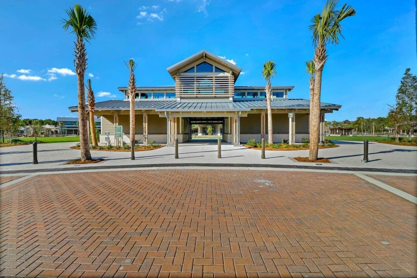 A modern building with a flat roof, large windows, and a covered entrance area.