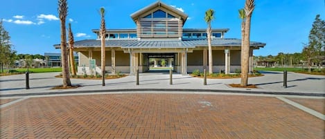 A modern building with a flat roof, large windows, and a covered entrance area.