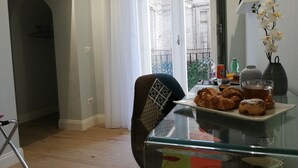 A dining area with a table set for breakfast, including pastries and a cup of tea. - Porta San Gennaro (Naples)