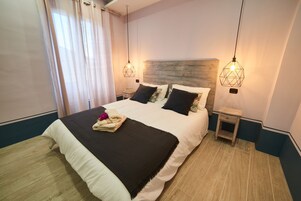 Cubrecamas, escritorio y espacio para trabajar con laptop 