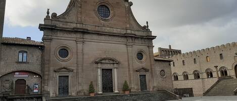 Un edificio storico con una cupola centrale, finestre ad arco e una scalinata che conduce all'ingresso.
