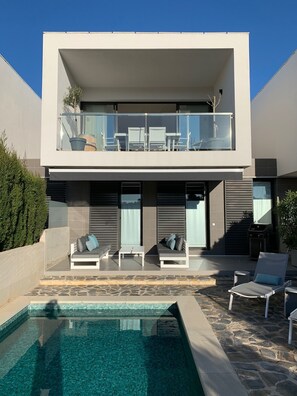 Una piscina al aire libre, tumbonas
