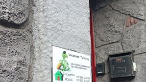 A stone wall with a sign for 'Locazione Turistica' and a small black device attached to it. - Apartment for tourist use in the center (Catania)