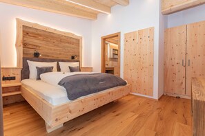 Una cama de madera con cabecera, una mesita de noche y un armario.