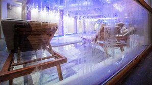 A view through a frosted glass window of a bar area with a wooden bar counter and seating.