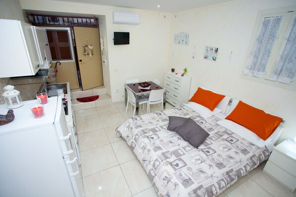 A hotel room with a bed, a desk, a chair, a wardrobe, and a bathroom.