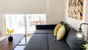 A modern living room with a grey sofa, yellow and white patterned cushions, a wooden coffee table with a potted plant, and a floor lamp. - Star Stay Miami / Orange@Brickell - King bed, Balcony & Free Parking (Miami)