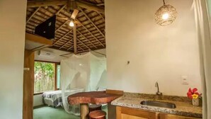 Una cucina con soffitto rustico, uno sgabello da bar in legno, un lavello e un lampadario.