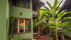 Un edificio a due piani con facciata verde e un piccolo portico.
