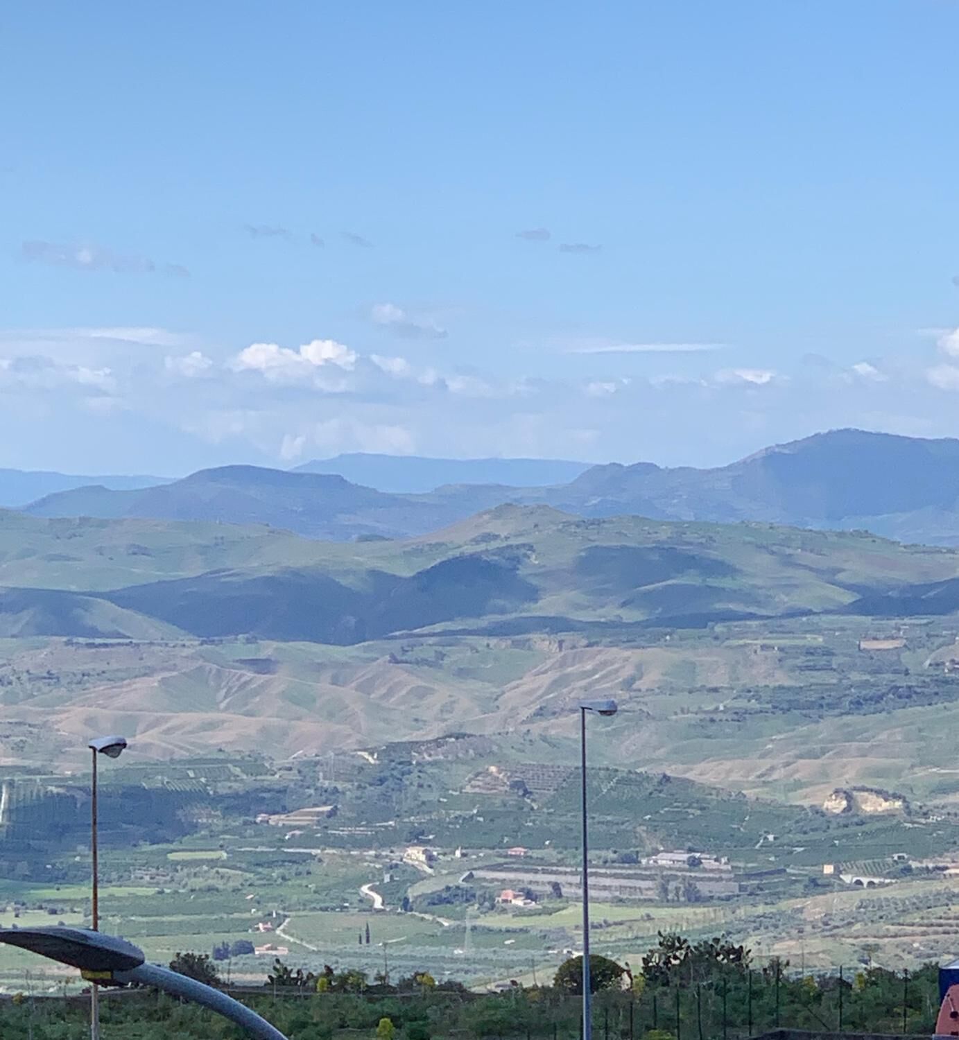 A panoramic view of a hilly landscape with a clear sky.