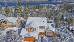 A snow-covered residential area with houses, a lake, and mountains in the background. - Valley View Cabin,Lake view, 6 bedrooms, Hot tub, walk distance to village (Big Bear Lake)