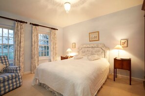 A bedroom with a large bed, two bedside tables with lamps, a chair, and a window with curtains. - Historic Hall Wing nr York & Leeds + free Hot tub! (Wighill)