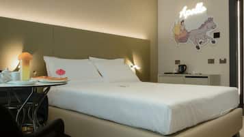 Camera d'hotel con un letto, una scrivania con una lampada, una macchina per il caffè e un quadro raffigurante un cavaliere.