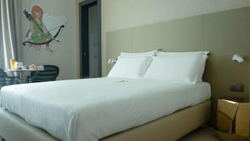 Ein Hotelzimmer mit einem großen Bett, einem kleinen Tisch mit Frühstücksgebäck, einem Stuhl und einer Wanddekoration.