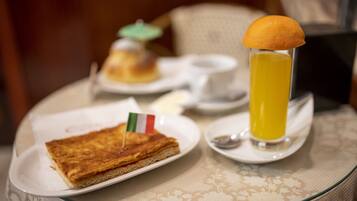 A breakfast setting with a slice of toast and a glass of orange juice on a table.