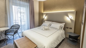 A hotel room with a bed, a desk, a chair, and a small table. - il Divino (Naples)