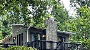 Een modern huis met een bakstenen gevel, grote ramen en een overdekte veranda.